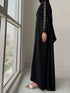 Woman wearing Haya Abaya paired with matching black chiffon hijab and gold accessories