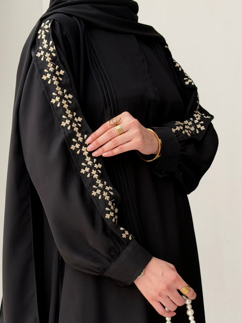 Lower pleat detail and fluid bottom hemline drape of black Haya Abaya